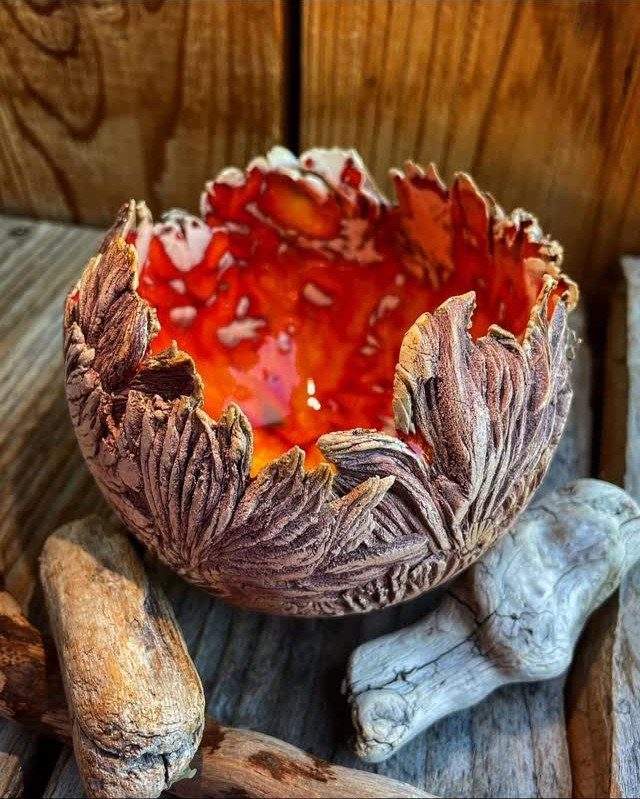 15 Living Room Natural Design Ideas with Organic Style 7 Ceramic bowl with leaf textures and orange glaze resting on weathered driftwood.