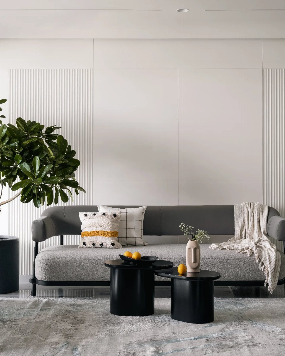 15 Living Room Natural Design Ideas with Organic Style 12 Grey modern sofa and black round coffee tables in a bright white room.